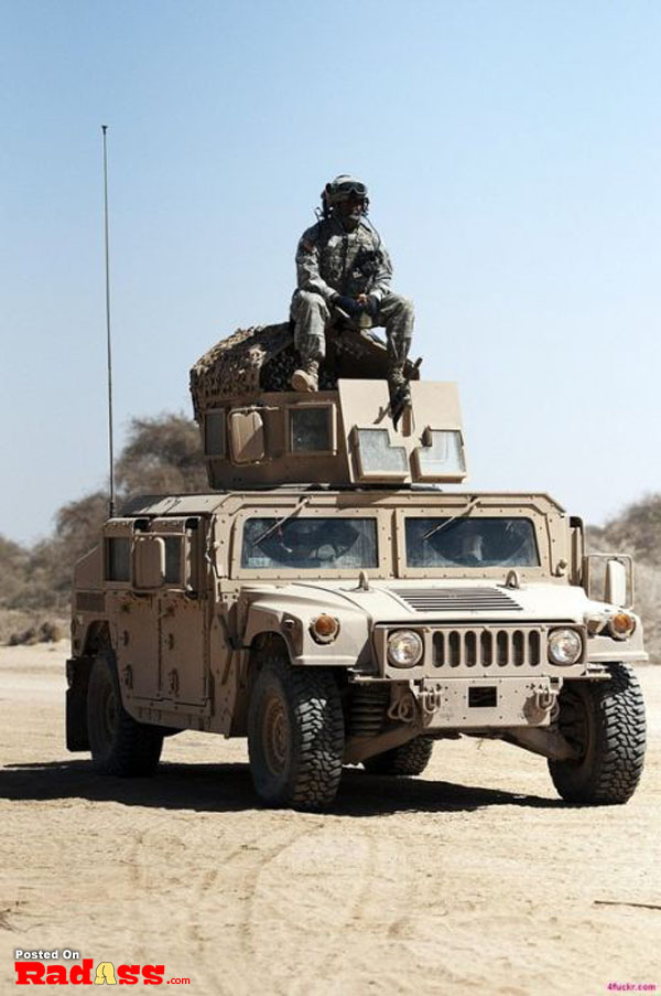 An American soldier is sitting on top of a military vehicle, representing our American heroes.