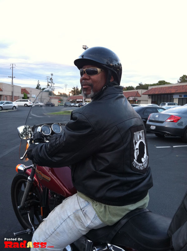 An American hero riding a motorcycle in a parking lot.