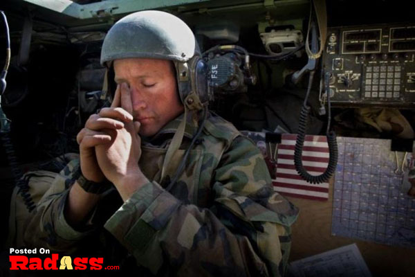 A soldier is praying, honoring American heroes.