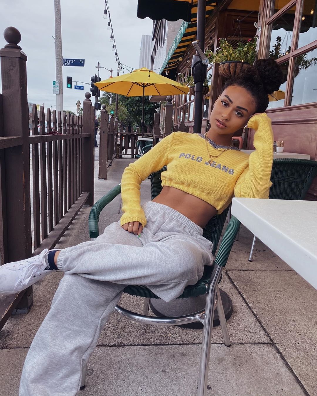 A woman sitting in a chair wearing a yellow crop top and grey sweatpants showcases The Many Shades of Instagram.