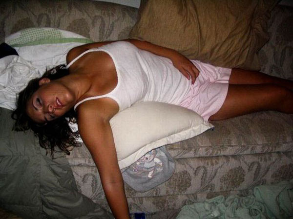 A woman lounging on a couch with pillows.