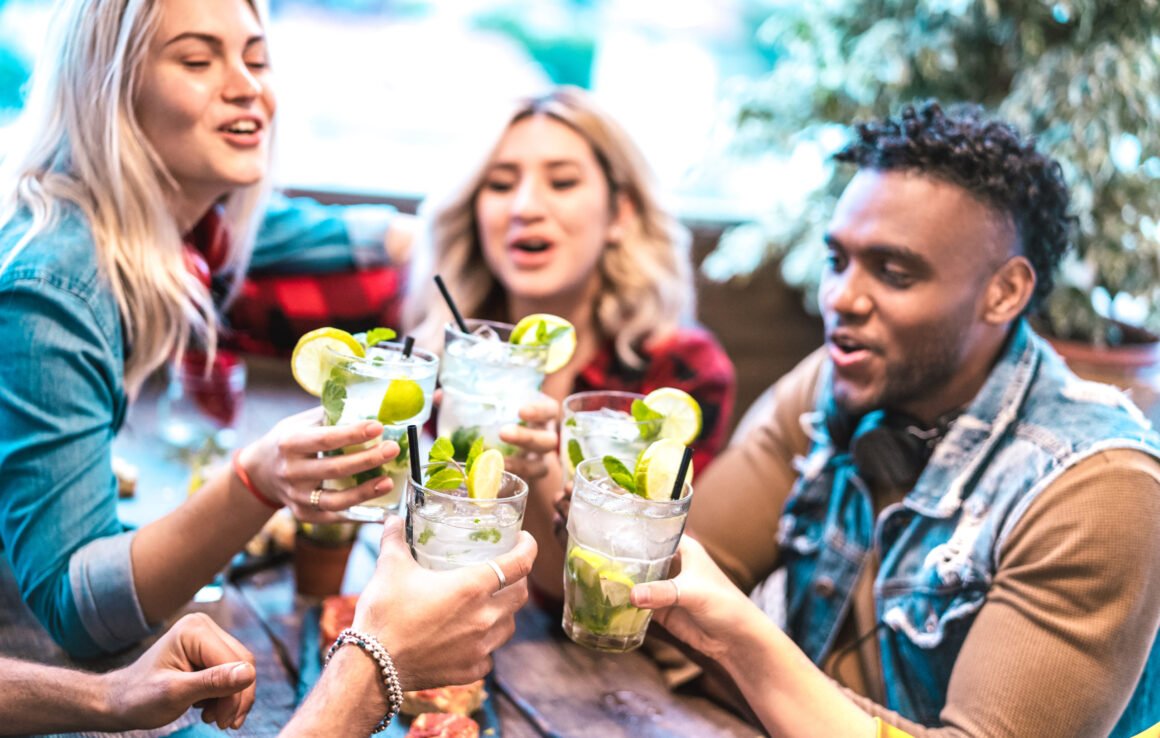 A group of friends practicing drinking etiquette at a bar.