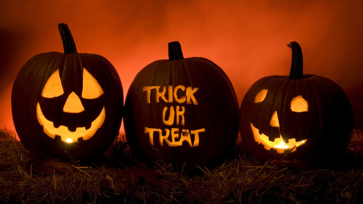 Three carved pumpkins with the words trick or treat, commemorating all Hallows Eve.