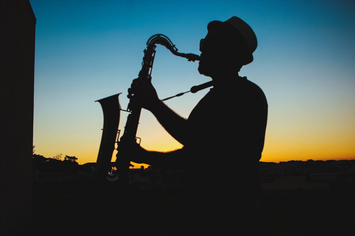 A silhouette of a man playing a saxophone at sunset, a tribute to the rich history of jazz.
