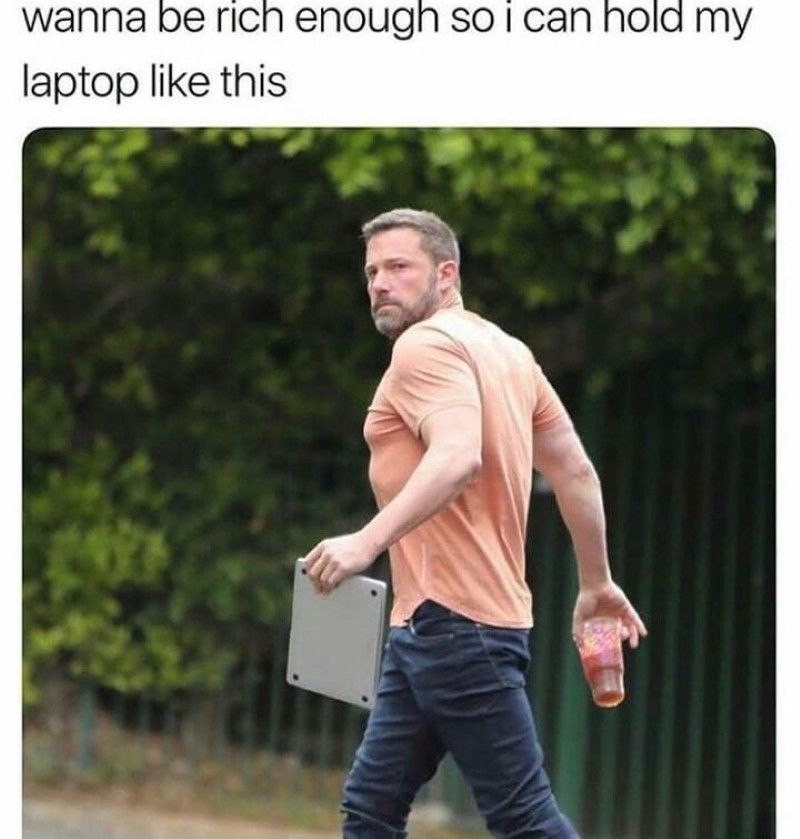 A man carrying a laptop with the text wanna rich enough so i can hold my laptop like this.