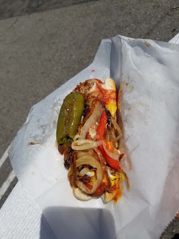 A hot dog on a white napkin.